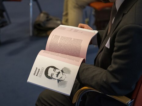 Ein aufgeschlagenes Buch mit einem Bild von Enver Simsek