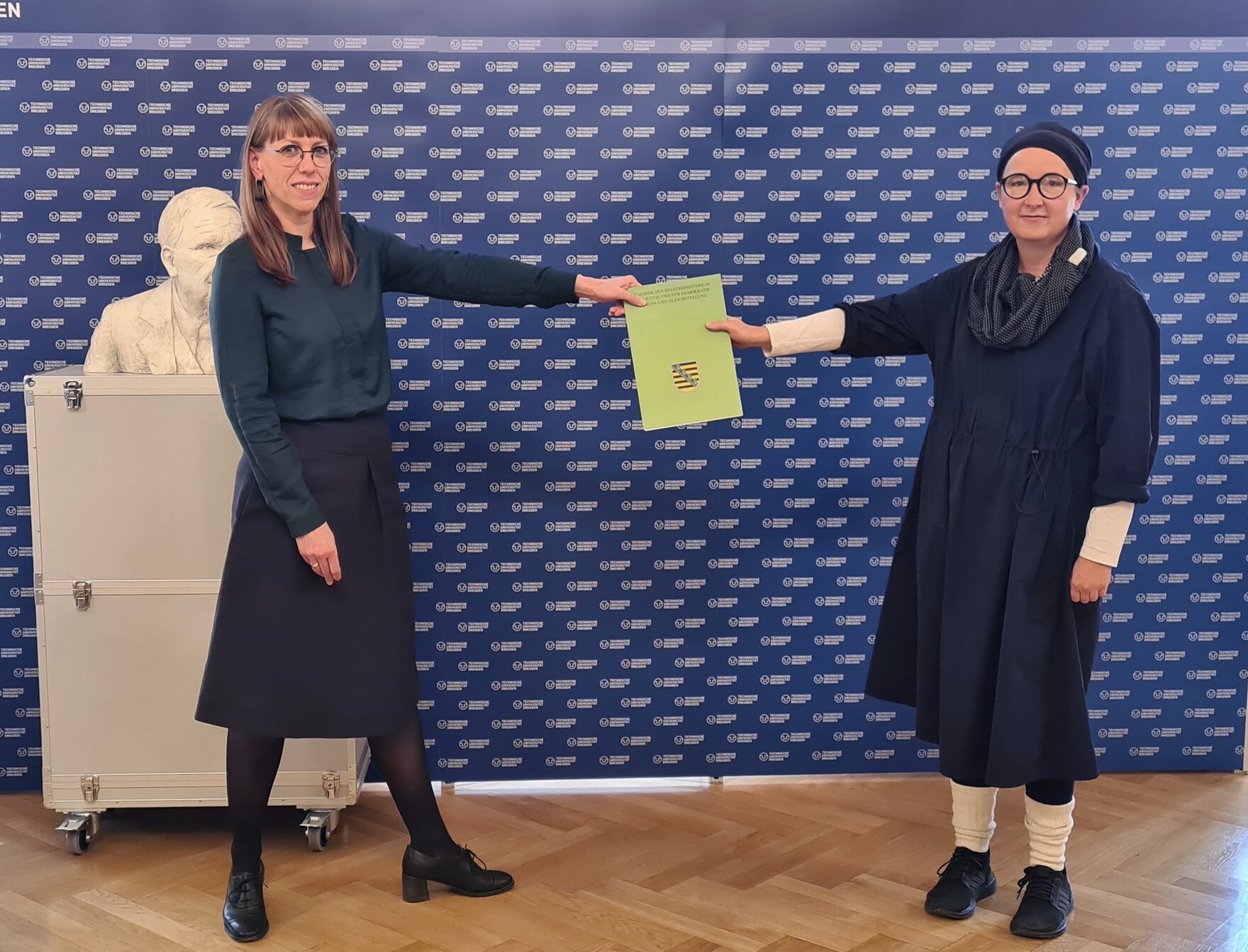 Das Bild zeigt wie Frau Staatsministerin Katja Meier den Fördermittelbescheid an Frau Prof. Anja Besand von der TU Dresden übergibt. 