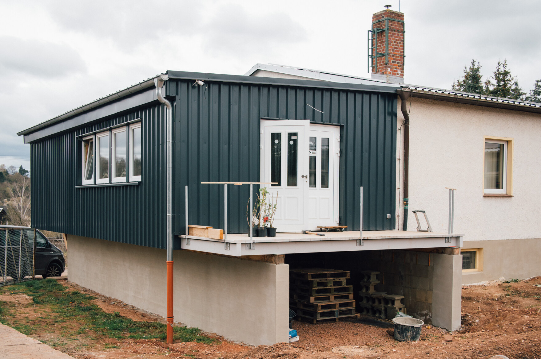 Zu sehen ist ein Haus mit Flachdach, an dem noch gearbeitet wird.