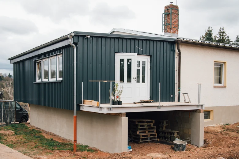 Zu sehen ist ein Haus mit Flachdach, an dem noch gearbeitet wird.
