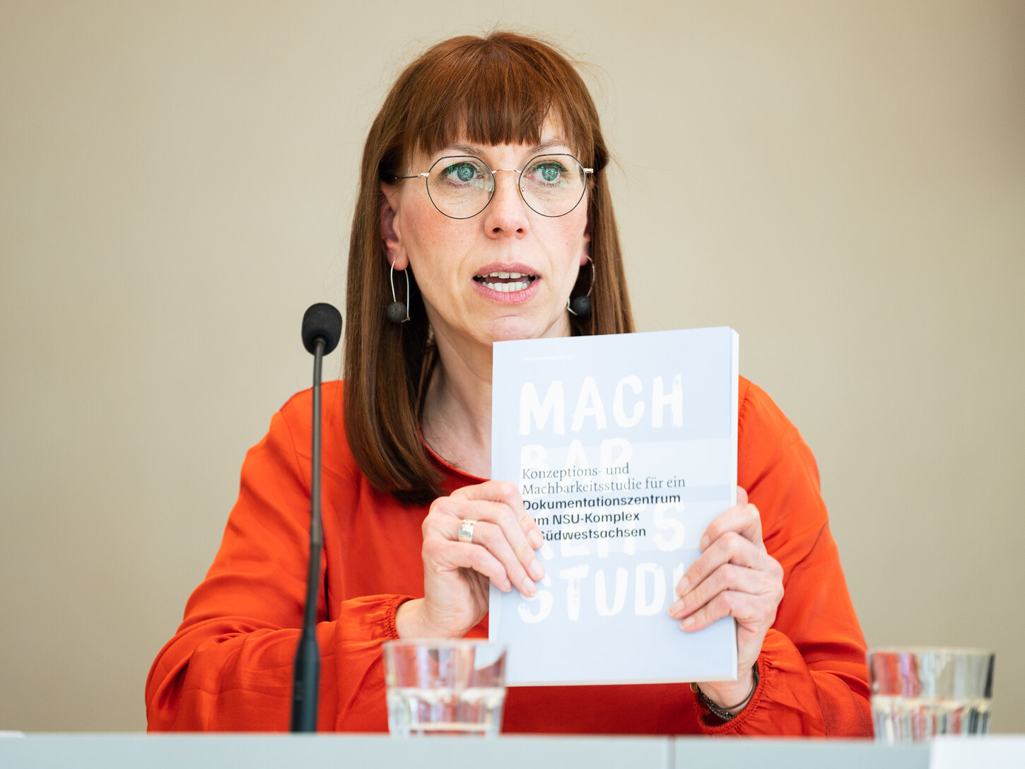 Demokratieministerin Katja Meier sitzt an einem Tisch. Sie hält ein Exemplar der Machbarkeitsstudie in den Händen.